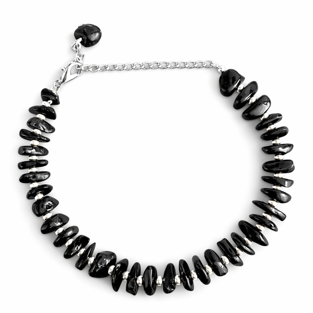 Bracelet with black tourmaline beads, white seed bead and silver chain on a white background