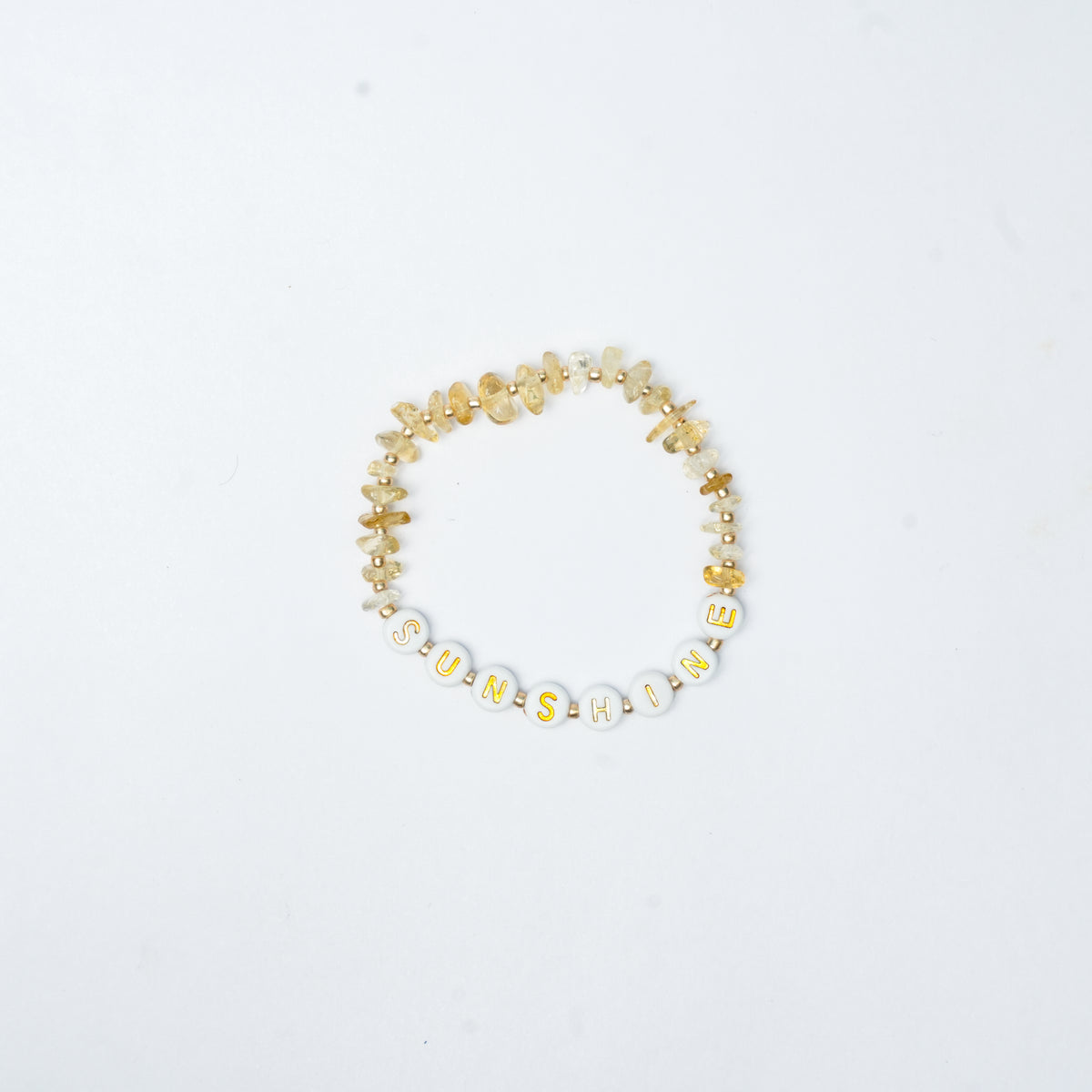 Sunshine letters with gold beads on a white background