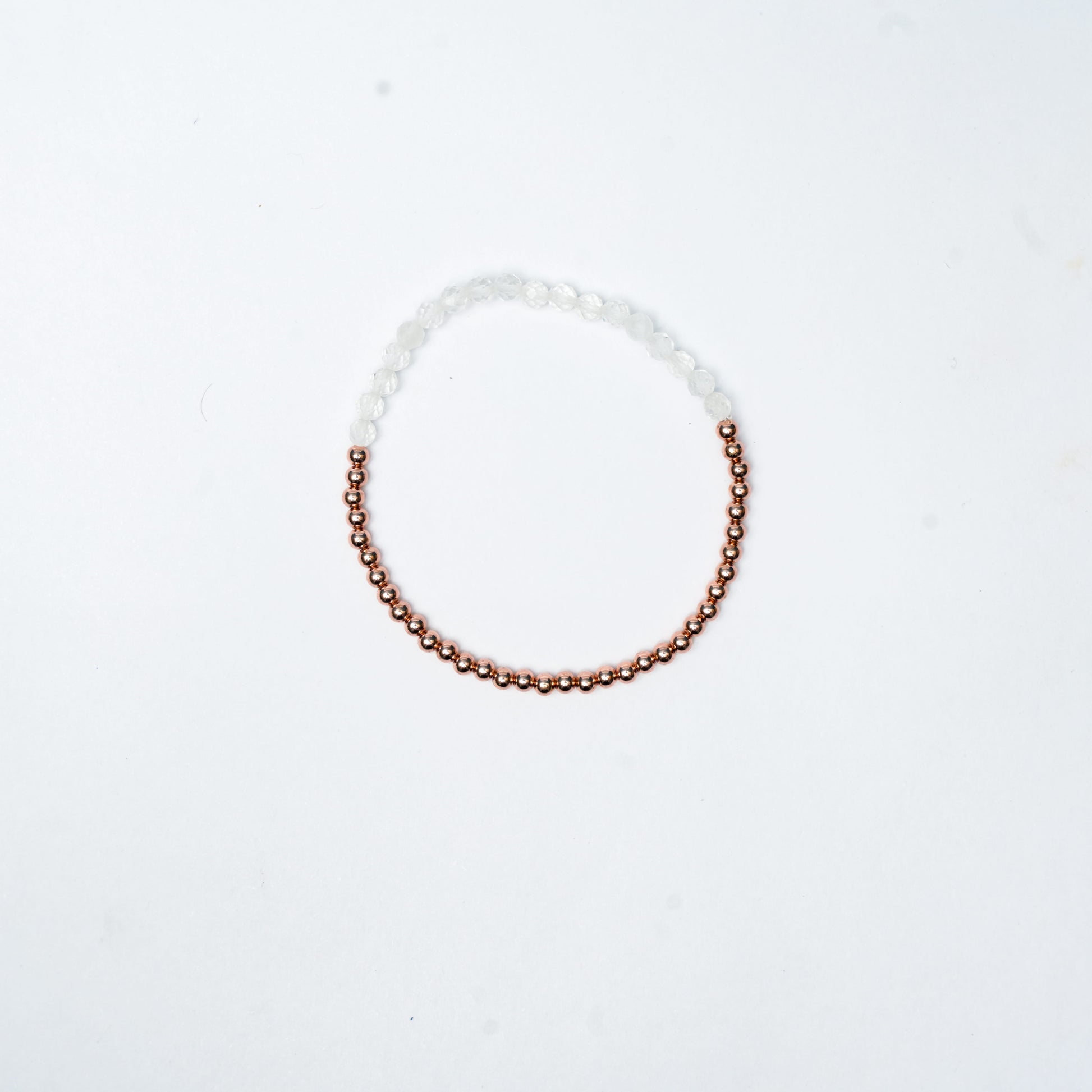 Stretch Bracelet with Clear Quartz beads, 3mm copper beads and elastic wire on a white 