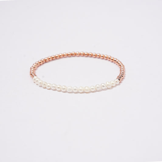 Stretch bracelet with pearl beads, 3mm copper beads copper beads and elastic wire on a white background     