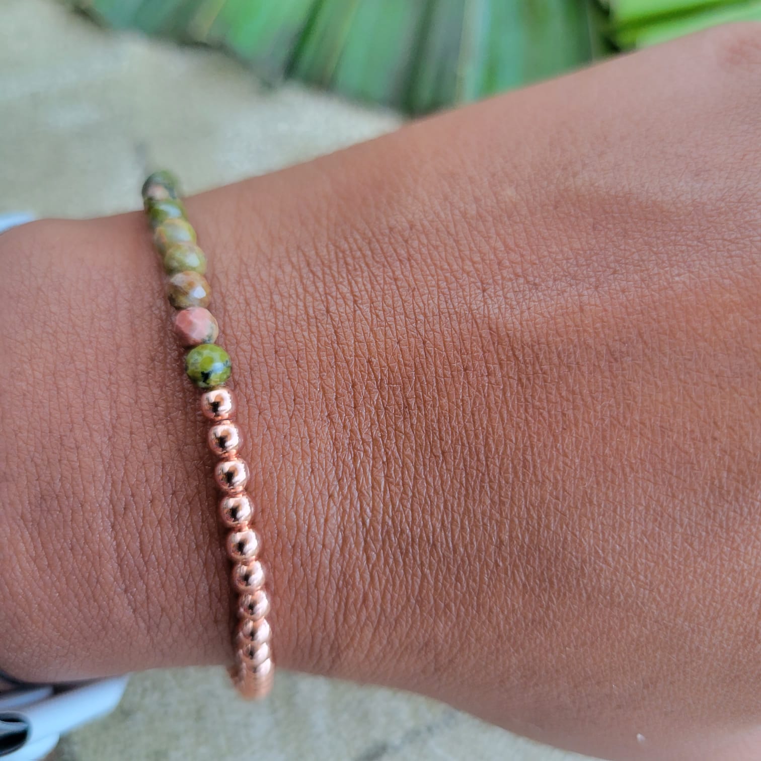 Unakite faceted beaded bracelet on a wrist with a natural background 