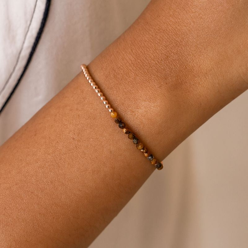 Tiger's eye faceted beaded bracelet on a wrist with a natural background