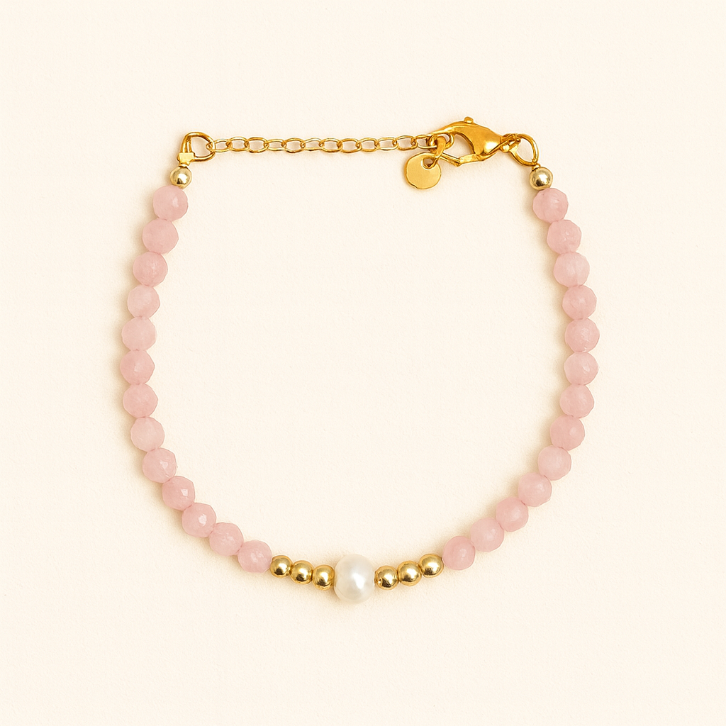 Bracelet with black beads, gold chain, and pearl on a beige background