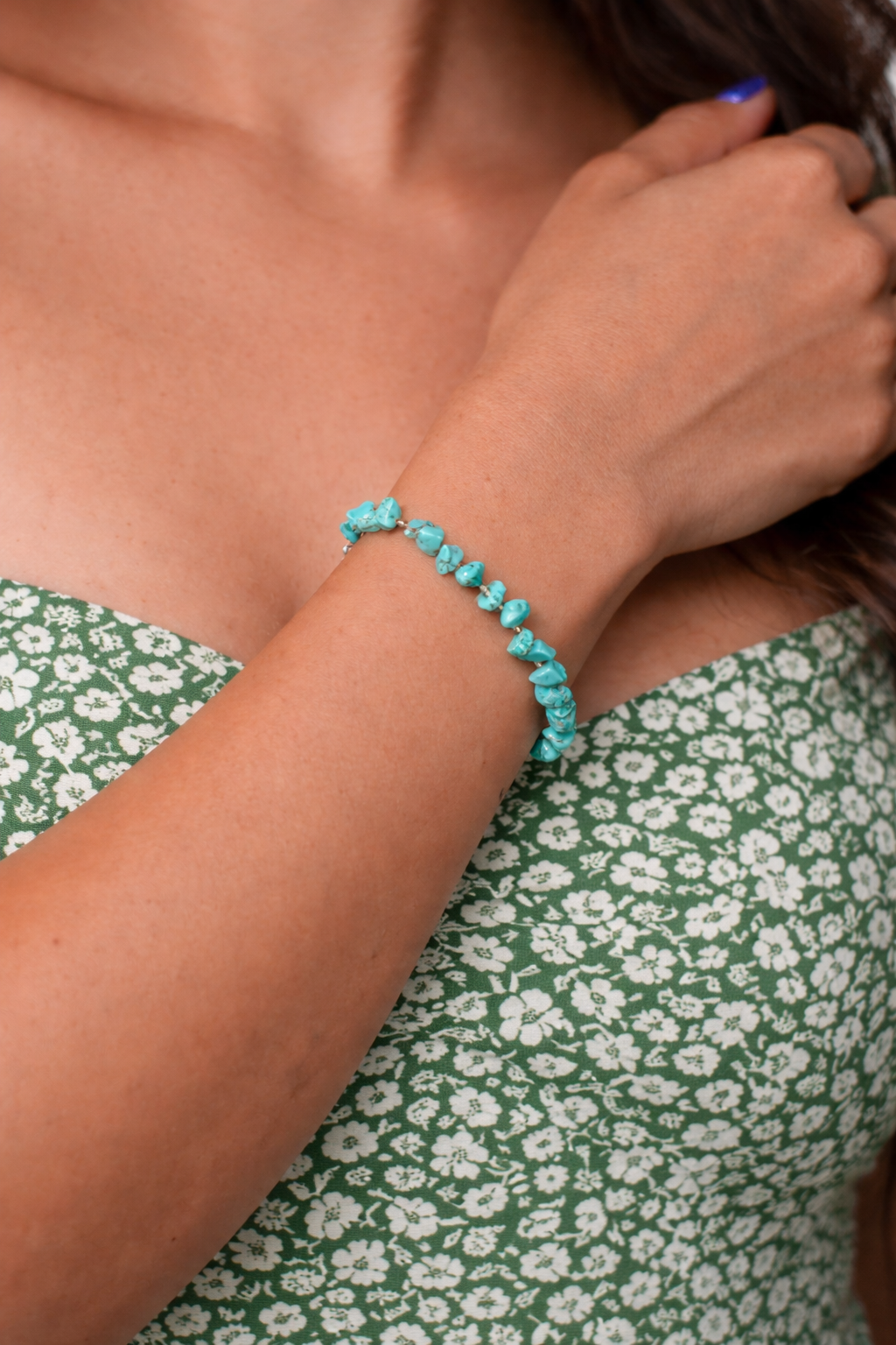 Turquoise chip beaded bracelet on a wrist with a natural background