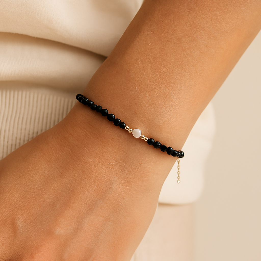 Black beaded bracelet on a wrist with a natural background